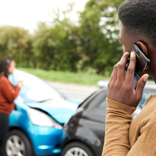 Man calling for assistance after car accident, bumpers hit. Consulting with New Orleans Car Accident Lawyer - Cueria Law Firm